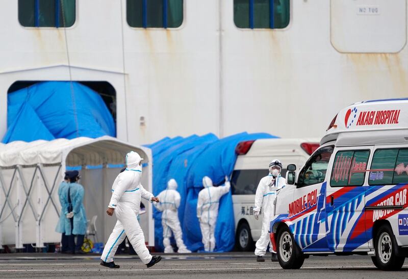 Personnel in protective gear walk towards the Diamond Princess cruise ship docked at the Daikoku Pier Cruise Terminal in Yokohama, south of Tokyo.  EPA