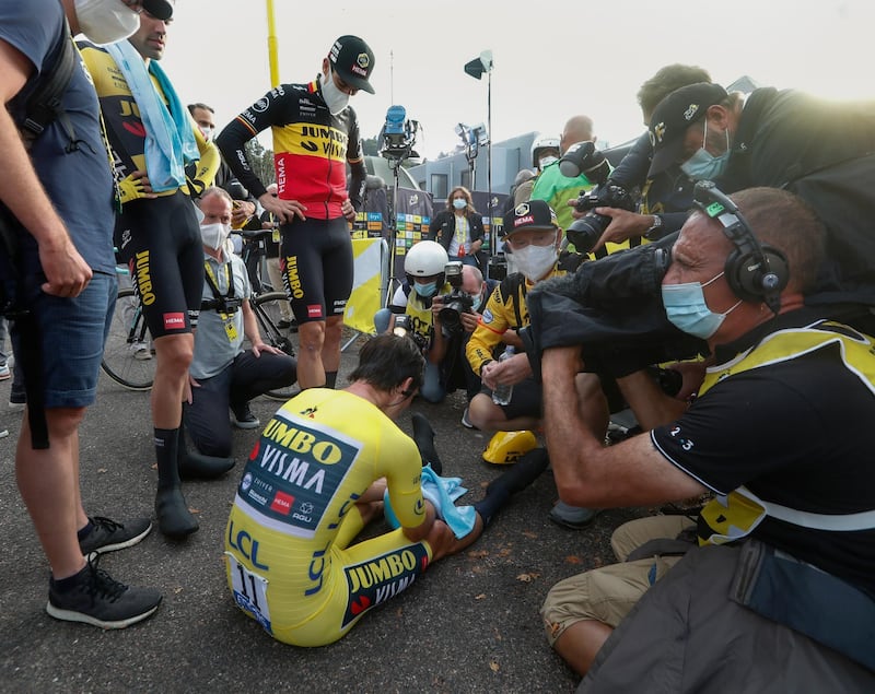 A distraught Primoz Roglic sits on the tarmac after losing the overall leader's yellow jersey. AP