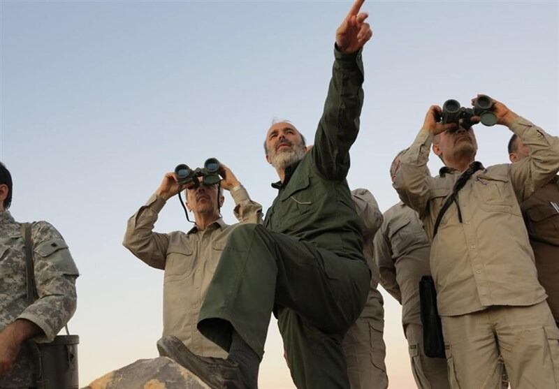 FILE - This file photo provided on Friday Oct. 20, 2017 by the government-controlled Syrian Central Military Media, shows Iran's army chief of staff Maj. Gen. Mohammad Bagheri, left looking into binoculars, and other senior officers from the Iranian military,  as they visit a front line in the northern province of Aleppo, Syria. As Syrian troops and their allies push toward final victory and the battle against Islamic State militants draws to an end, new fronts are opening up, threatening an even broader confrontation. The U.S., Israel and Turkey all have deepened their involvement, seeking to protect their interests in the new Syria order. (Syrian Central Military Media, via AP, File)