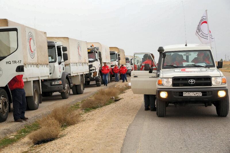 This picture shows an aid convoy of the red crescent arriving at the Rukban desert camp for displaced Syrians along Syria's border with Jordan on February 06, 2019. An aid convoy reached displaced Syrians in desperate need of assistance near the Jordanian border on February 06 in the first such aid delivery in three months, the Red Crescent said. A convoy of 133 trucks carrying aid including food and clothes for children reached the outskirts of the Rukban camp, a Syrian Arab Red Crescent spokeswoman said. / AFP / Syrian Red Crescent