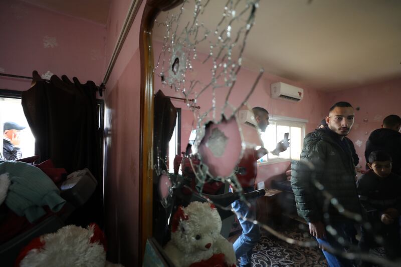 Palestinians at a house stormed by Israeli soldiers during operation to arrest a suspected gunman in the West Bank city of Jenin. A Palestinian man died of after being injured in the raid, health authorities said. EPA