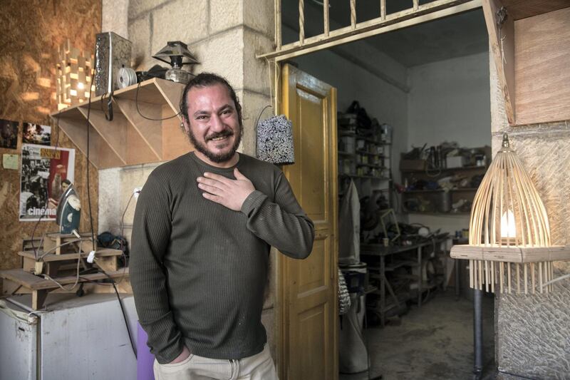 Alaa Hilu ,a self-trained upcycler, which means he takes that which is discarded and turns it into art or useful things. In Hilu's workshop, the screen from a tear gas mask has become a lamp. (Photo by Heidi Levine for The National).