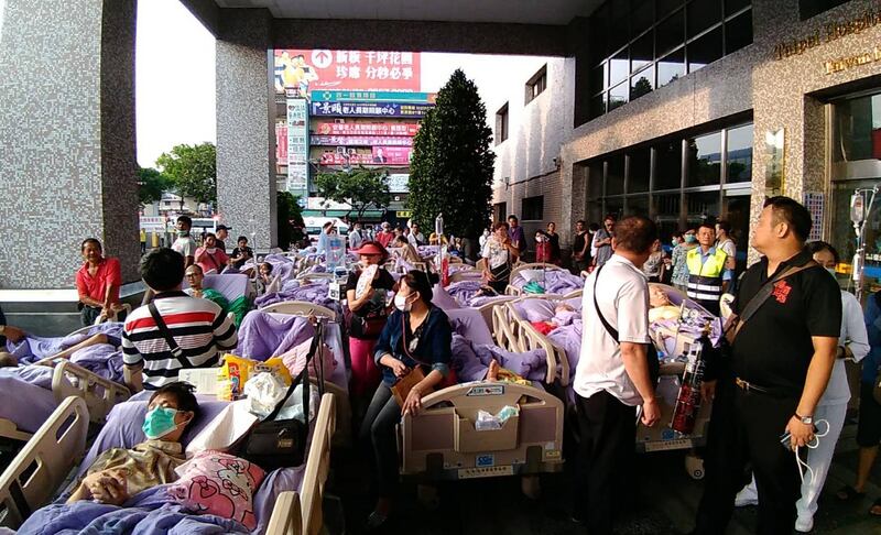 This photograph by Taiwan agency CNA Photo taken on August 13, 2018 shows bed-ridden patients outside the entrance to a hospital in New Taipei City after being evacuated following a fire on the seventh floor of a hospice. - Nine people were killed and 15 injured in a blaze that broke out early on August 13 at the hospice for the terminally ill, near Taiwan's capital Taipei, fire officials said. (Photo by CNA PHOTO / CNA PHOTO / AFP) / - Taiwan OUT - China OUT - Hong Kong OUT - Macau OUT / -----EDITORS NOTE --- RESTRICTED TO EDITORIAL USE - MANDATORY CREDIT "AFP PHOTO / CNA PHOTO" - NO MARKETING - NO ADVERTISING CAMPAIGNS - DISTRIBUTED AS A SERVICE TO CLIENTS