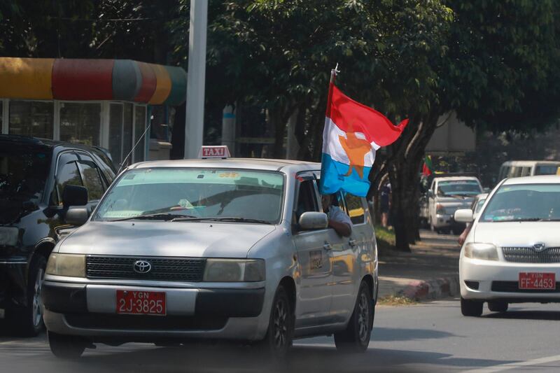 Myanmar military supporters riding a vehicle wave a military flag as they go around Yangon, Myanmar. AP