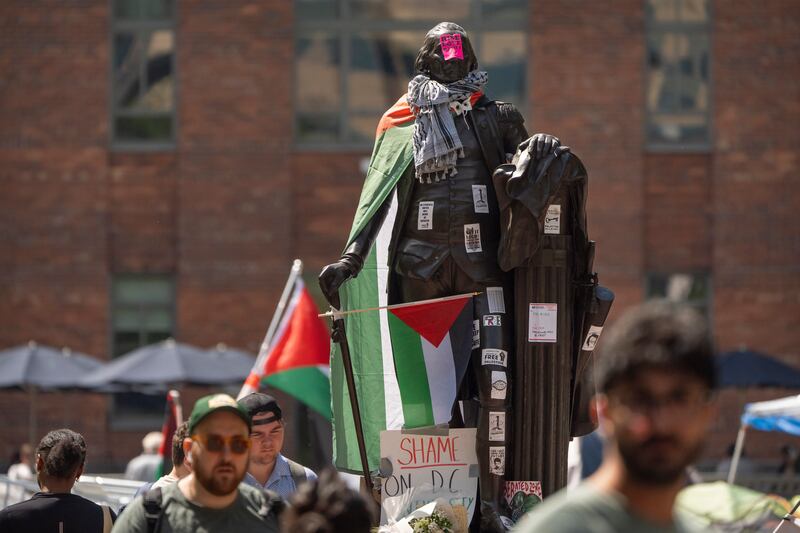 Stickers and Palestinian flags cover a statue of George Washington at an encampment by students protesting against the Israel-Gaza war at George Washington University. AP