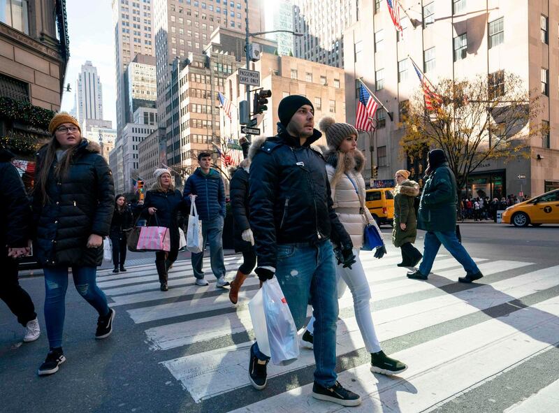 (FILES) In this file photo taken on November 23, 2018 shoppers and pedestrians walk past stores on Fifth Avenue in New York. Early sales data released November 26, 2018 and over the weekend suggested a strong start to the US holiday shopping season but analysts said it was too soon to declare victory overall. As of 1500 GMT, US shoppers had already doled out $531 million in online sales on "Cyber Monday," according to Adobe Analytics. 
 / AFP / Don EMMERT
