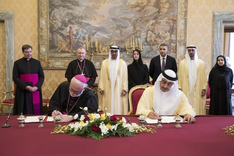 Sheikh Mohamed bin Zayed, back third left, watches as Sheikh Abdullah bin Zayed, Minister of Foreign Affairs and International Cooperation, signs a memorandum of understanding with Archbishop Paul Gallagher, Vatican Secretary for Relations with States. Watching them are Cardinal Pietro Parolin, Vatican Secretary of State, back second left, Reem Ibrahim Al Hashimi, Minister of State for International Cooperation, back fourth left, Khaldoon Khalifa Al Mubarak, CEO and Managing Director, Mubadala, and Chairman of the Abu Dhabi Executive Affairs Authority, back fifth left, Mohammed Mubarak Al Mazrouei, Undersecretary of the Crown Prince Court of Abu Dhabi, back sixth left, and Dr Hessa Al Otaiba, UAE Ambassador to Spain and Non-Resident Ambassador to the Vatican, back right. Ryan Carter / Crown Prince Court - Abu Dhabi