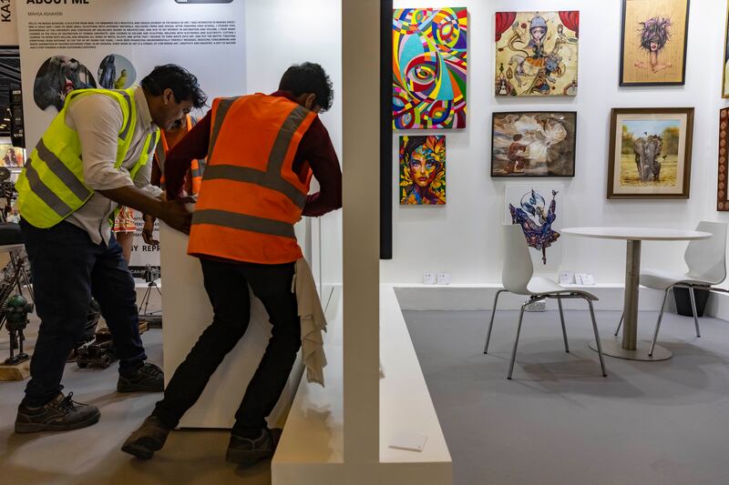 Finishing touches are made to the Masha Ashayeri stand, on the left, while other stands are ready for the show
