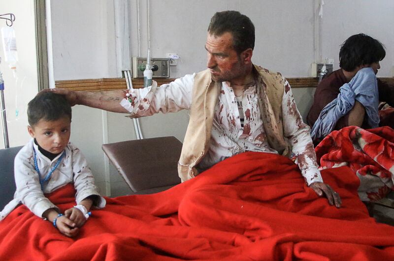 A father and son require aid after being wounded in a suicide bomb. Reuters