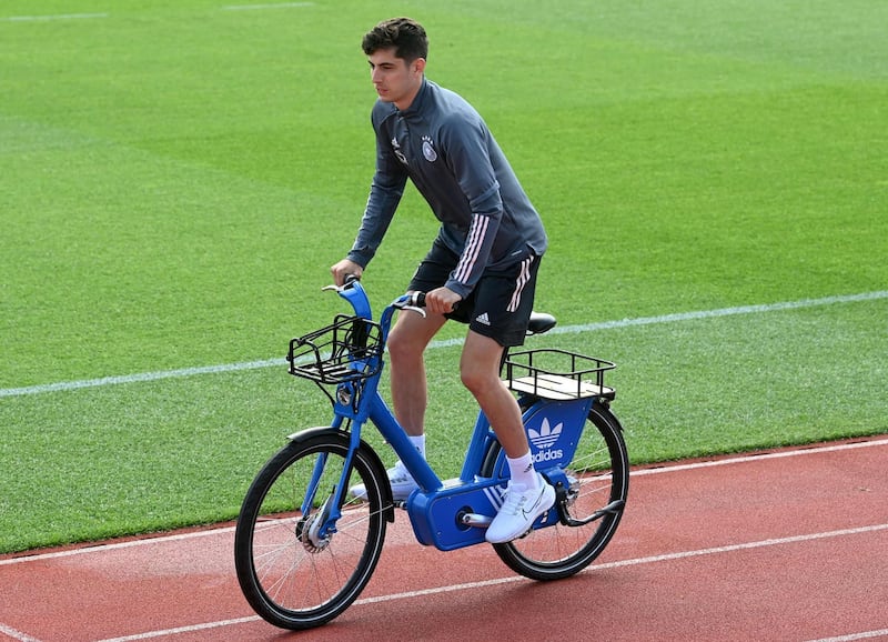Germany forward Kai Havertz arrives on a bicycle before a training session at the World of Sports Campus in Herzogenaurach. AFP