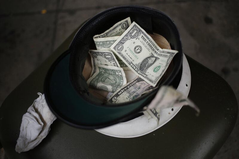 U.S. dollar banknote tips sit in a street musician's hat in the French Quarter of New Orleans, Louisiana, U.S., on Wednesday, Feb. 7, 2018. New Orleans prepares for its most popular tourism time of year as the Mardi Gras festival gets set to parade through the city on the last day of the Carnival season. Photographer: Luke Sharrett/Bloomberg