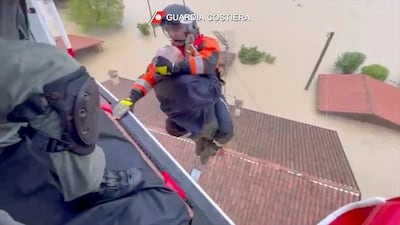 Italian Coast guard rescue a man from the roof of a flooded house in the town of Faenza. Guardia Costiera/AP