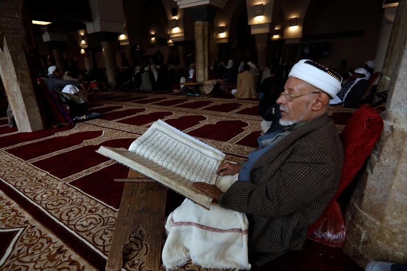 A Yemeni reads verses from the holy Quran as Islamic scholars of Yemen attend a gathering at a mosque in Sana'a, Yemen. EPA
