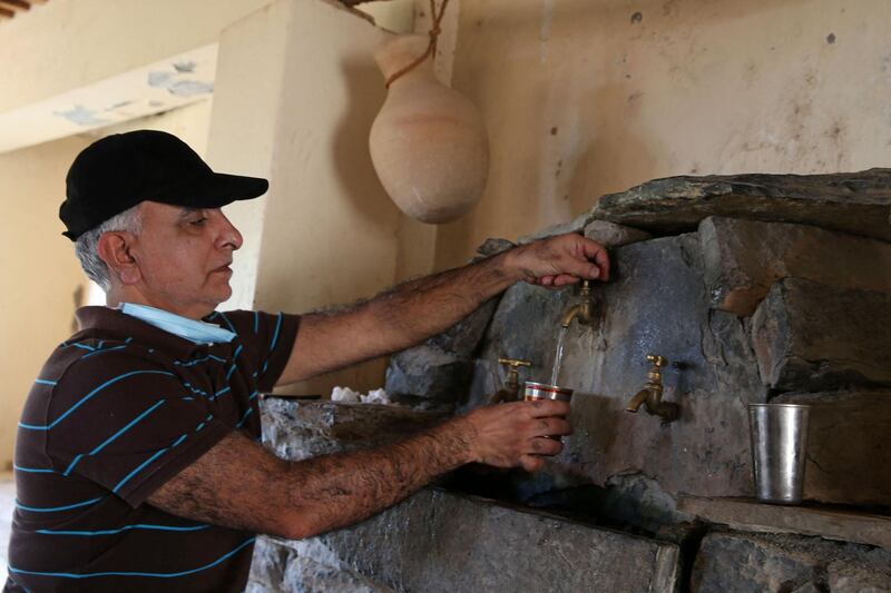 A local resident fills his cup with water at a hotel in Misfat Al Abriyeen, a popular location in a region famous for walking trails and stories of genies. AFP