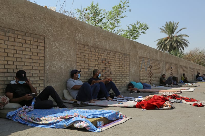 Protesters sit in front of the Ministry of Electricity building in Baghdad. Reuters