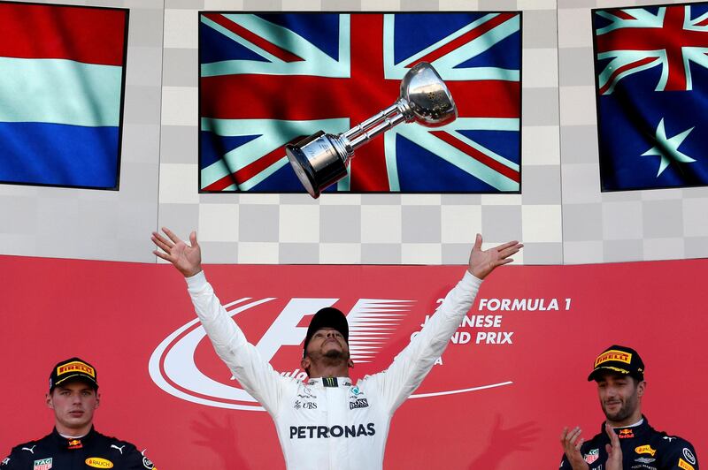 Mercedes' Lewis Hamilton of Britain celebrates winning the race next to Bull's Daniel Ricciardo of Australia and Max Verstappen of the Netherlands. Toru Hanai / Reuters