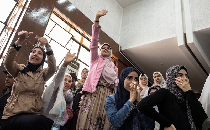 Relatives of members of the Muslim Brotherhood wave during a trial session for them and former Egyptian president Mohamed Morsi who was ousted in 2013, at a make-shift courthouse in southern Cairo. AFP