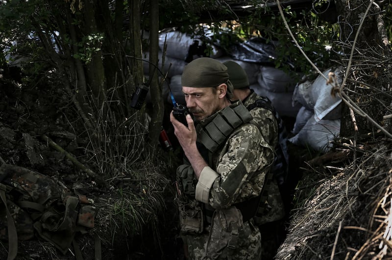 A Ukrainian serviceman speaks on a radio at a front line in the Donbas region. AFP