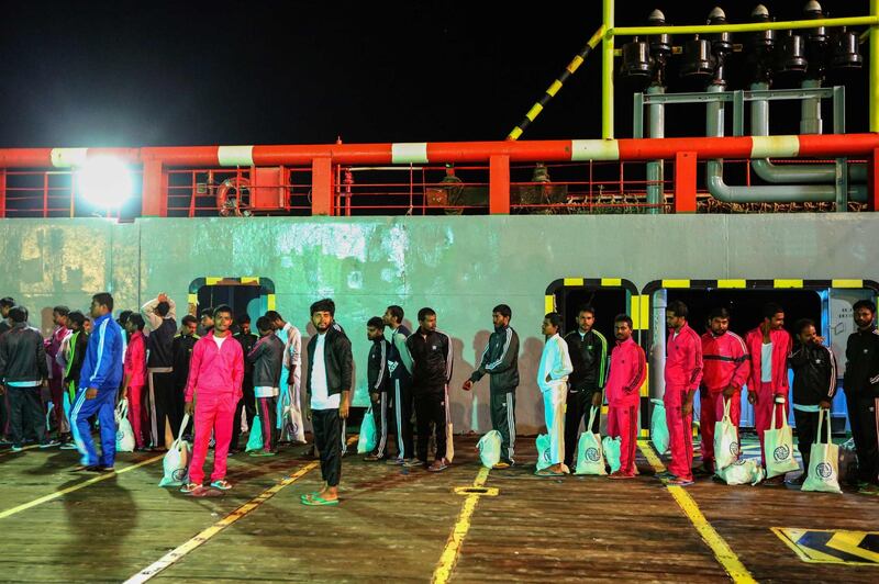 Migrants walk along the quay after disembarking from the vessel as they arrive to Zarzis harbour in the southern coast of Tunisia. AFP