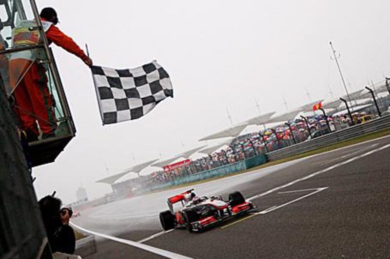 Jenson Button takes the checkered flag in Shanghai.