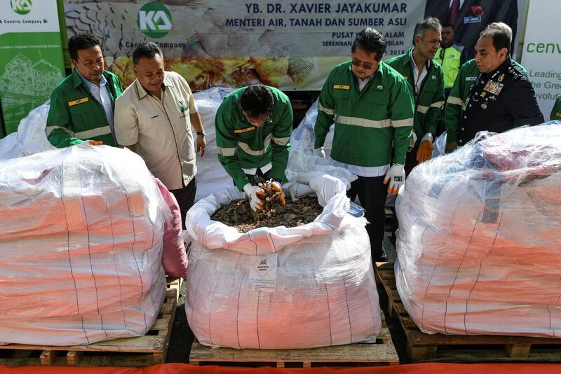 Malaysia's Minister of Water, Land and Natural Resources, Xavier Jayakumar (C) inspects a huge amount of pangolin scales seized by Royal Malaysian Customs before being incinerated at Port Dickson on December 6, 2018. Malaysian authorities incinerated 2.8 tonnes of seized pangolin scales as part of a government campaign against illegal wildlife smuggling. / AFP / Mohd RASFAN

