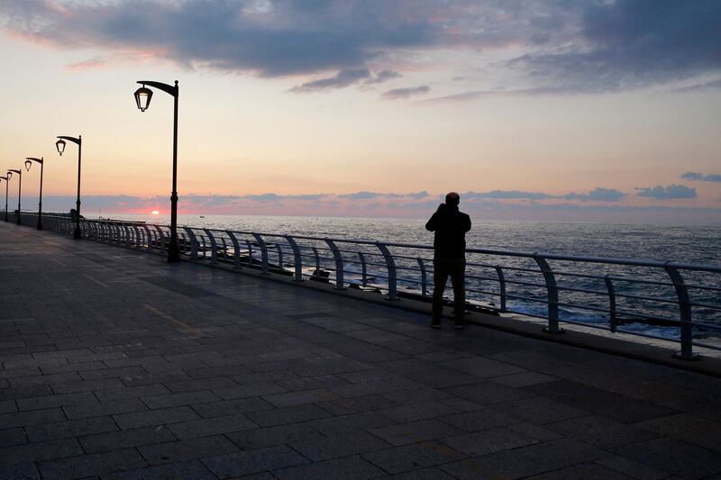 A man takes a picture of the sunset at Beirut's seaside corniche in Lebanon. AP