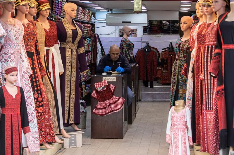 A traditional dress shop keeper reads the Quran, on the second day of Muslim's holly month of Ramadan in Downtown Amman, Jordan. EPA