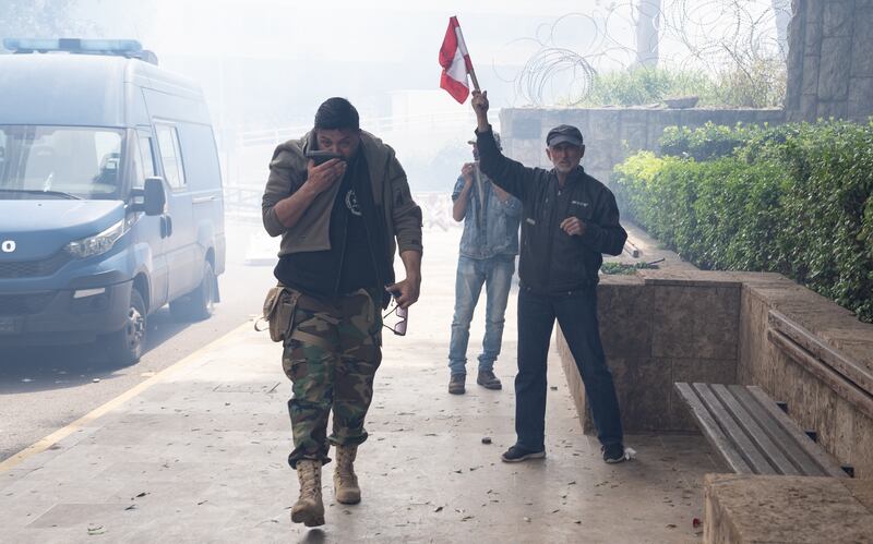 A veteran waves the Lebanese flag as retired soldiers try to storm the government palace in Beirut on March 22. Matt Kynaston / The National