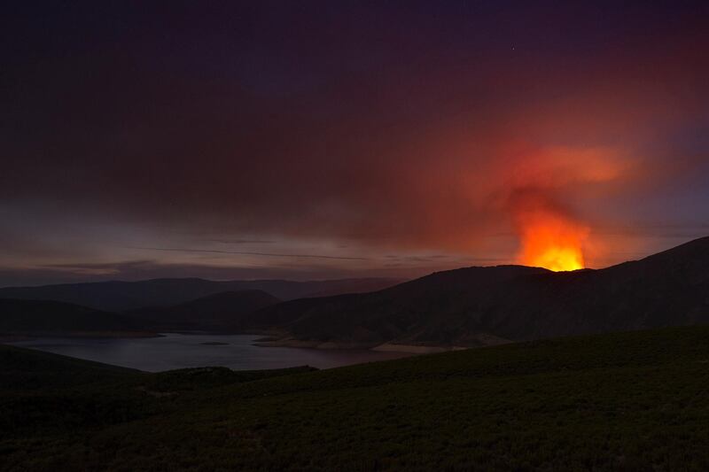 Flames behind a mountain after a forest fire broke out in Invernadeiro natural park in Ourense, northwestern Spain. EPA
