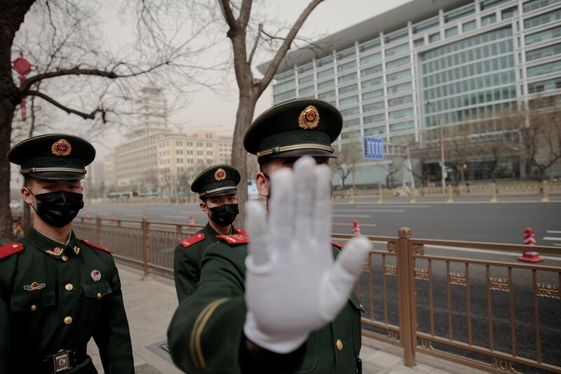 A paramilitary policemen gestures towards a photographer as a sandstorm hits Beijing. Damir Sagolj / Reuters