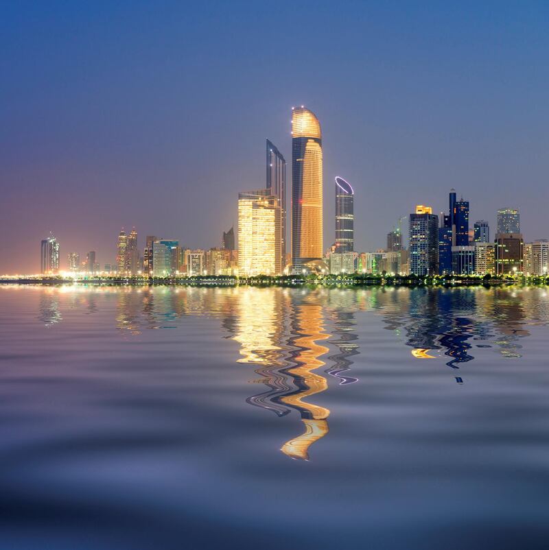 Night skyline with reflections of skyscrapers on Corniche in Abu Dhabi in United Arab Emirates UAE