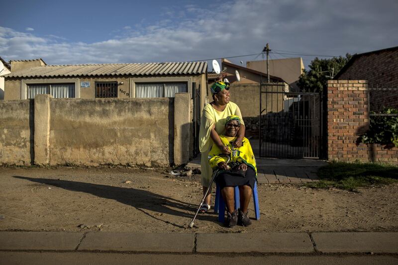 Flora Wesi, 90, who has lived on her street since 1952, waits with her neighbour Mapule Setle for the body of Winnie Mandela to pass by on its way to the funeral at the Orlando Stadium in Soweto, South Africa. Charlie Shoemaker / Getty Images