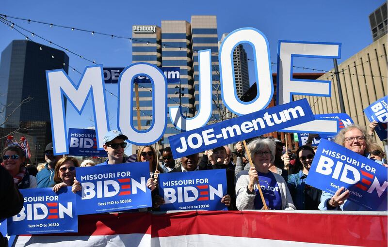 Supporters hold up signs before Joe Biden holds a rally at Kiener Plaza Park in St. Louis, Missouri on March 7, 2020. AFP