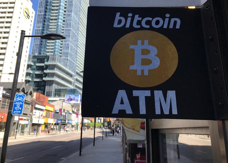 FILE PHOTO: A sign is seen outside a business where a Bitcoin ATM is located in Toronto, Ontario, Canada June 3, 2017.  REUTERS/Chris Helgren/File Photo