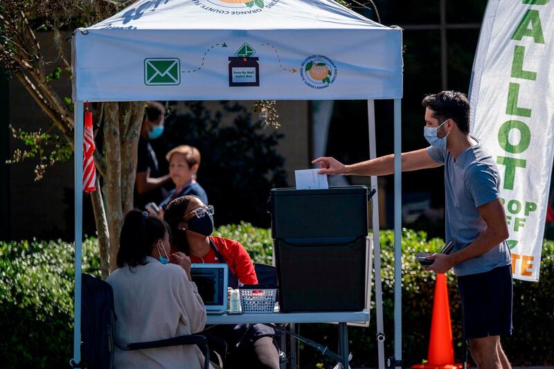 A voter drops off his vote at a ballot box at the Alafaya Branch Library in Orlando, Florida. AFP