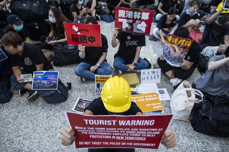 Demonstrators hold placards in the arrival hall. Bloomberg