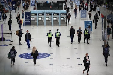 Police officers wearing protective face masks walk through London's Waterloo station, during the morning rush hour on Wednesday. Under the latest government coronavirus directives, office workers have been urged to work from home. Reuters