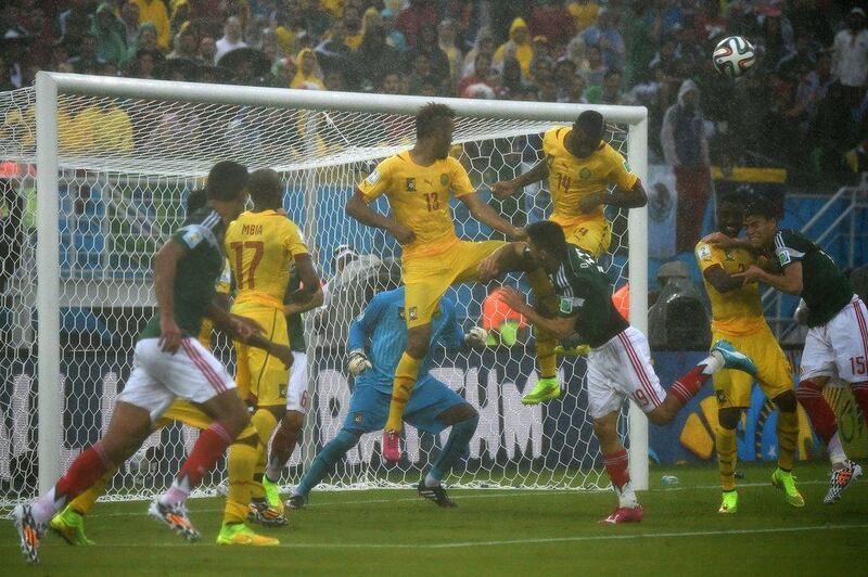 Mexico's Oribe Peralta, centre, fights with Cameroon forward Eric Choupo-Moting, third left, and defender Aurelien Chedjou, third right, during their World Cup 2014 Group A match on Friday. Christophe Simon / AFP