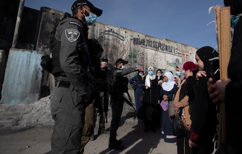 epa09138737 Israeli soldiers and police officers block Palestinian women from crossing at Kalandia checkpoint between West Bank and Jerusalem to attend the first Friday prayer of the Muslim holy month of Ramadan in Al Aqsa Mosque in Jerusalem’s old city, 16 April 2021. Israeli authorities limited the access to Palestinians who have already been vaccinated against COVID-19. Muslims around the world celebrate the holy month of Ramadan by praying during the night time and abstaining from eating, drinking, and sexual acts during the period between sunrise and sunset. Ramadan is the ninth month in the Islamic calendar and it is believed that the revelation of the first verse in Koran was during its last 10 nights.  EPA/ATEF SAFADI