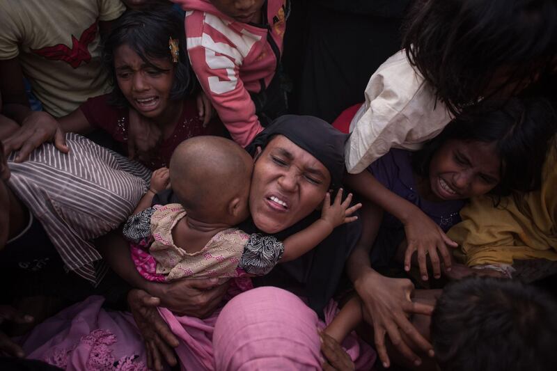 Rohingya Muslim refugees react as police and officials attempt to control a surging crowd as they wait to be called to receive food aid of rice, water, and cooking oil at a relief centre at the Kutupalong refugee camp in Cox's Bazar. Ed Jones / AFP Photo