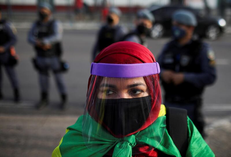 A woman wearing a protective face mask and shield attends an anti-racism demonstration in Manaus, Brazil. Reuters