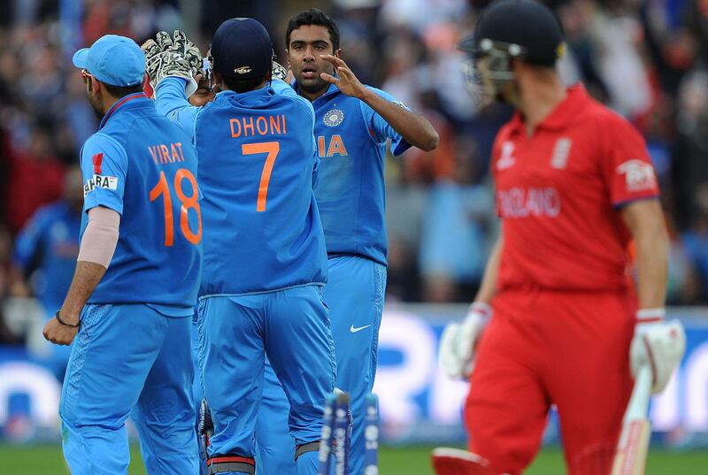 India's Mahendra Sing Dhoni (C) celebrates with bowler India's Ravichandran Ashwin (2-R) after stumping England's Jonathan Trott (R) during the 2013 ICC Champions Trophy Final cricket match between England and India at Edgbaston in Birmingham, central England on 23, June 2013.  India scored 129 runs for the loss of seven wickets after the rain delayed match was reduced reduced to the bare minimum of 20 overs per side required to produced a result.   AFP PHOTO/ANDREW YATES
 RESTRICTED TO EDITORIAL USE
 *** Local Caption ***  408782-01-08.jpg