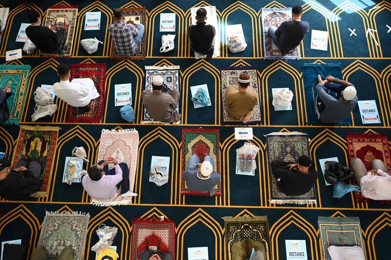 Worshippers socially distanced and wearing face masks kneel on their personal prayer mats during Friday prayers at Madina Masjid, Sheffield's central mosque, in Sheffield, northern England. AFP