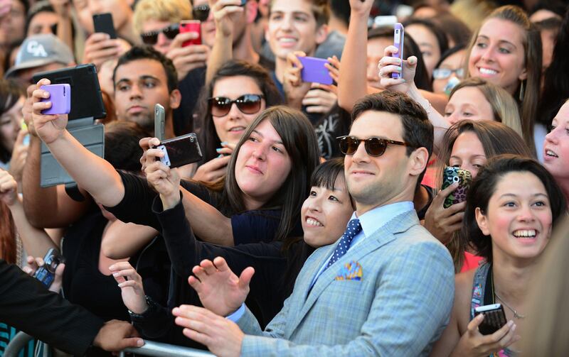 Justin Bartha poses for pictures on the cellphones of eager fans at the Los Angeles premiere of the film 'The Hangover Part 3' in Los Angeles, California on May 20, 2013. The film opens nationwide on May 23. AFP PHOTO/Frederic J. BROWN
 *** Local Caption ***  162111-01-08.jpg