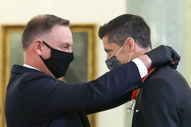 Polish national soccer team captain Robert Lewandowski receives the Commander's Cross of the Order of Polonia Restituta from Poland's President Andrzej Duda during a ceremony at the Presidential Palace in Warsaw, Poland, March 22, 2021. Jakub Szymczuk/KPRP/Handout via REUTERS ATTENTION EDITORS - THIS IMAGE WAS PROVIDED BY A THIRD PARTY. POLAND OUT. NO COMMERCIAL OR EDITORIAL SALES IN POLAND. NO RESALES. NO ARCHIVES