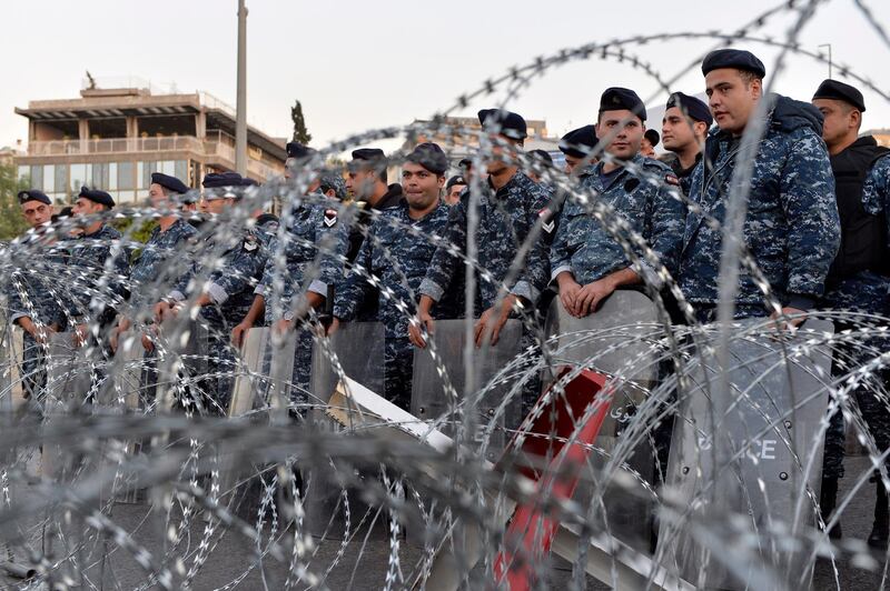 Lebanese riot policemen stand guard behind barbed wire that blocks a road leading to the Presidential palace during a protest to demand the formation of a new government in Baabda, east Beirut.  EPA