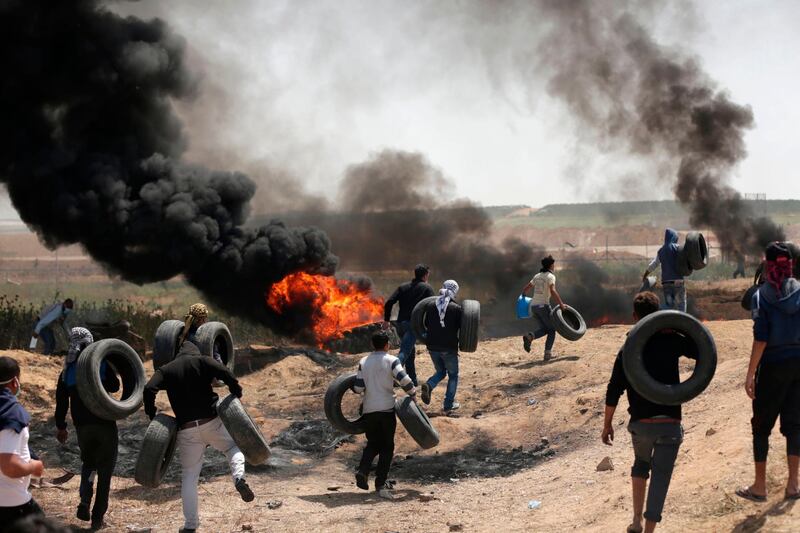 Palestinian men burn tyres on the Israel-Gaza border in 2018 during the second consecutive Friday of mass protests. AFP