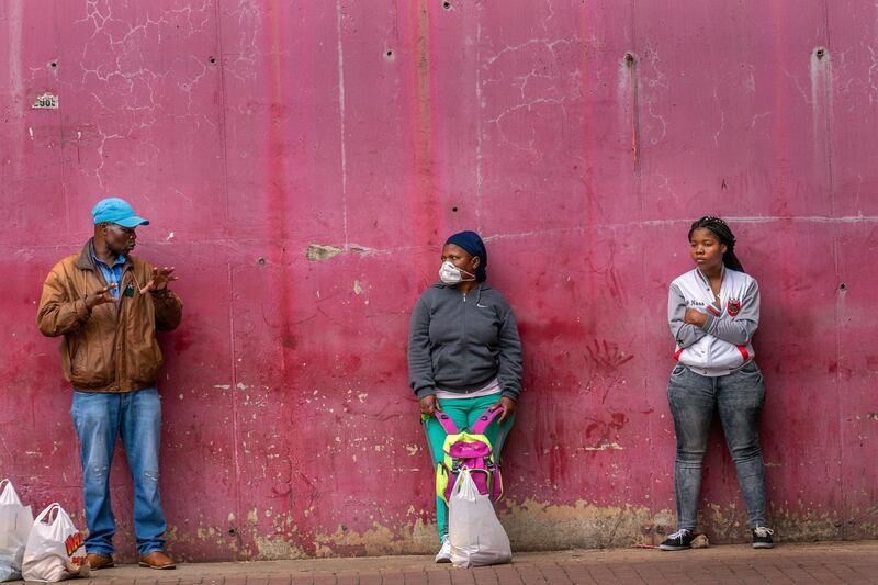 Residents of the Alexandra township of Johannesburg, South Africa, wait in line to enter a grocery store Friday April 3, 2020. South Africa went into a nationwide lockdown for 21 days in an effort to control the spread of the coronavirus. The new coronavirus causes mild or moderate symptoms for most people, but for some, especially older adults and people with existing health problems, it can cause more severe illness or death.(AP Photo/Jerome Delay)
