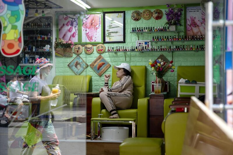 A pedestrian is reflected in the window of a nail salon during a nationwide social distancing and stay-at-home order imposed due to coronavirus in Ho Chi Minh city, Vietnam. Bloomberg