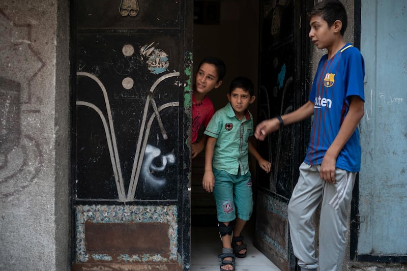 8-year-old Mohamed al-Dalo, center, who was shot in the leg during a demonstration, stands at the entrance of his house in Gaza City. Ever since Hamas launched demonstrations in March against Israel's blockade of Gaza, children have been a constant presence in the crowds. Since then, U.N. figures show that 948 children under 18 have been shot by Israeli forces and 2,295 have been hospitalized, including 17 who have had a limb amputated. AP